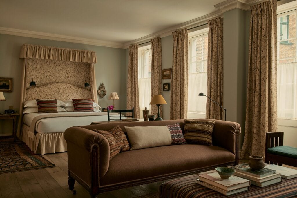 The elegant beige interiors of The Zetter's penthouse suite, featuring floral curtains and matching bed frame.