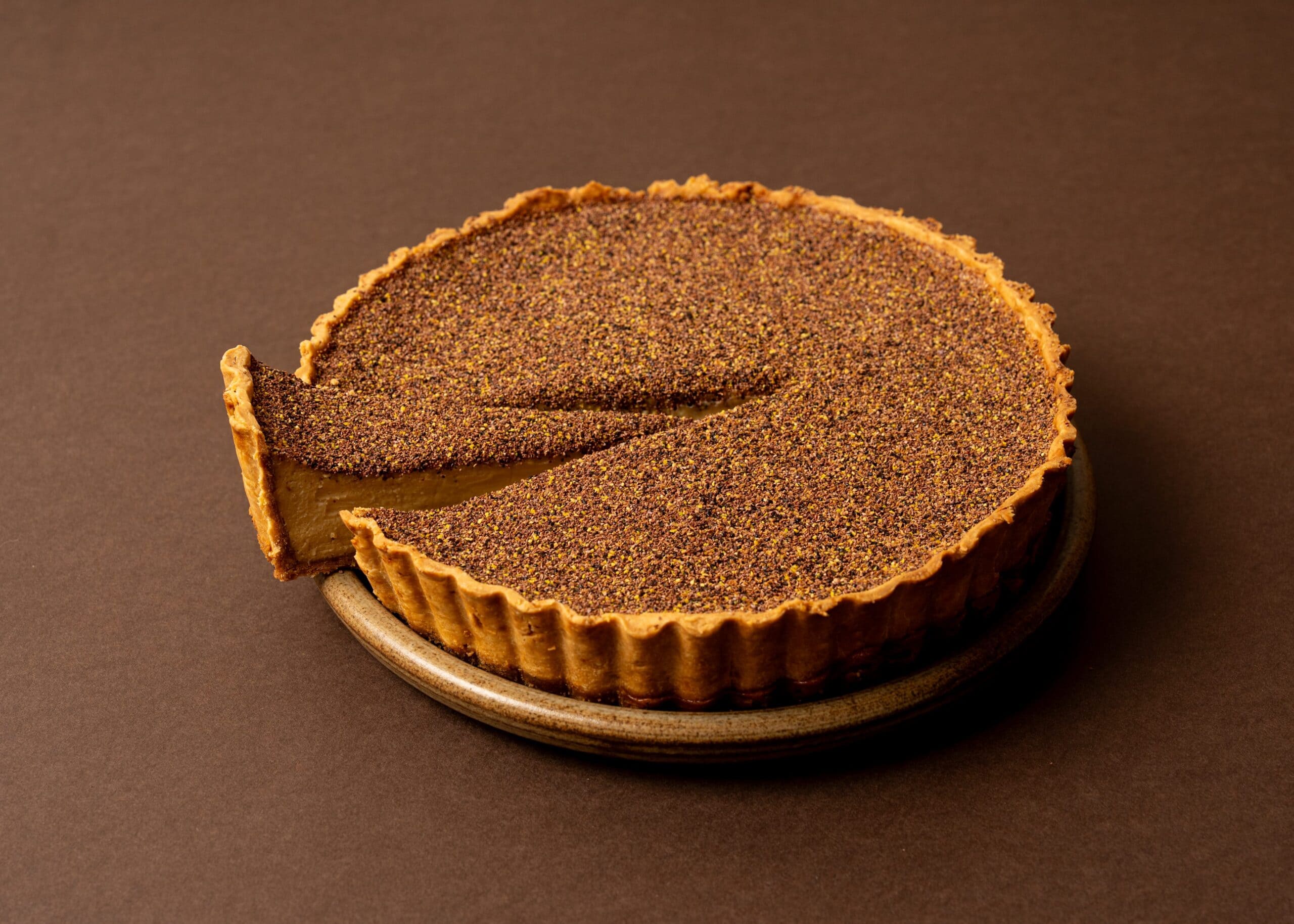 Wattleseed custard tart with dark speckled crust at Arthur Surry Hills Sydney