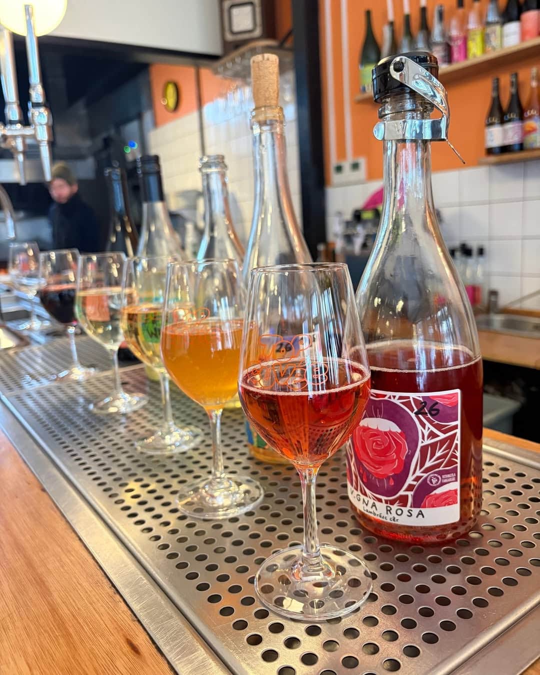A rainbow of different wines with half glass pours in front of each, lined up along the bar at Top Cuvee in Highbury.