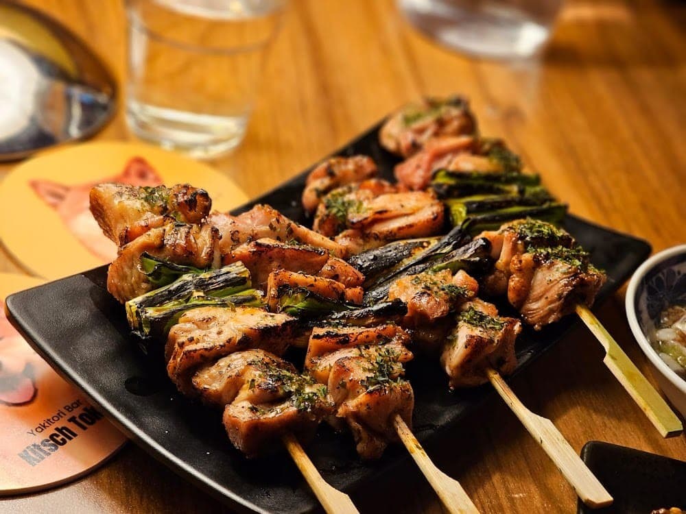 Yakitori Bar Kitsch Tokyo charcoal grilled chicken and spring onion skewers on black plate Chatswood Sydney
