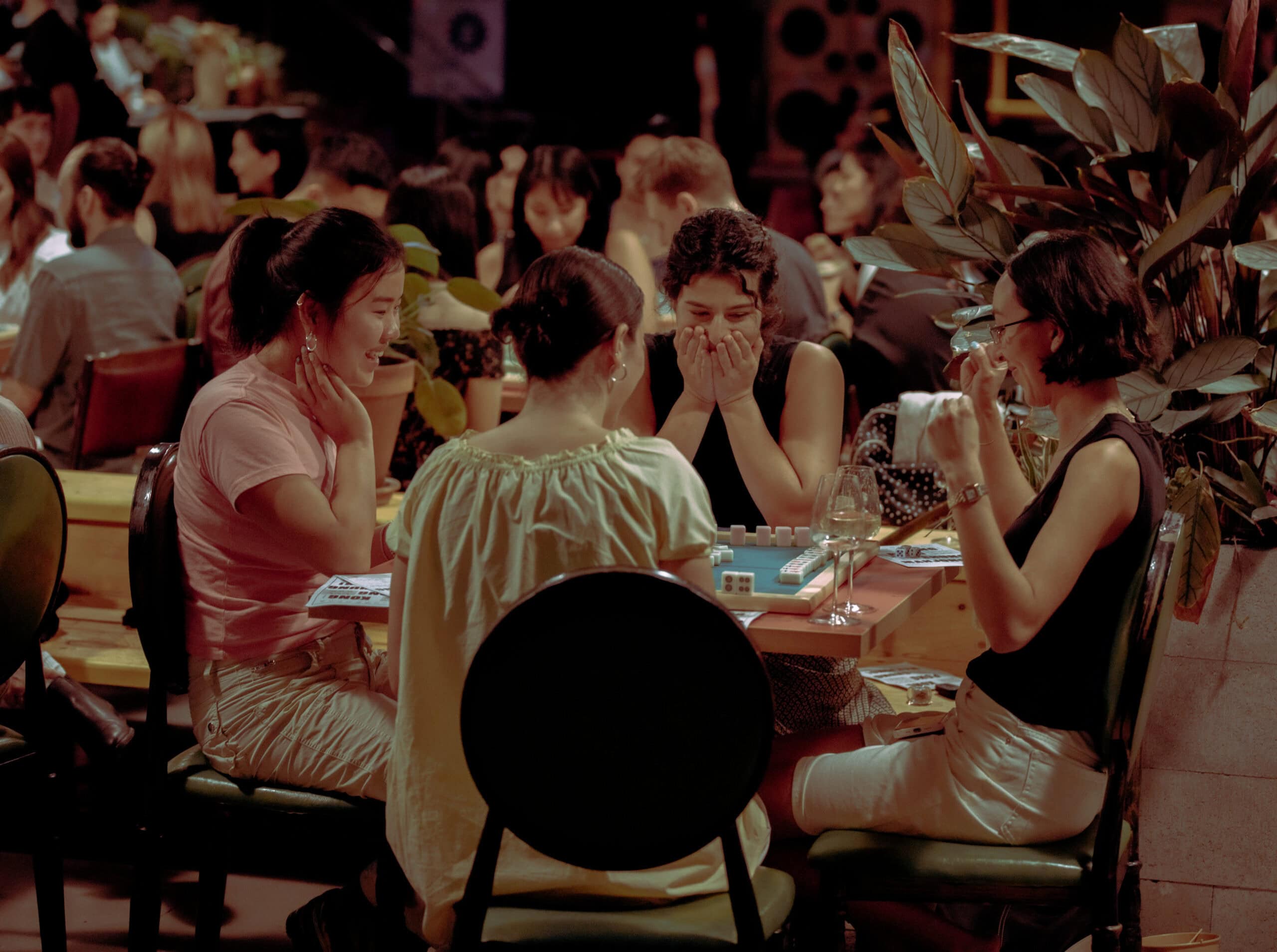 Friends laughing over mahjong game at No Flowers Sydney
