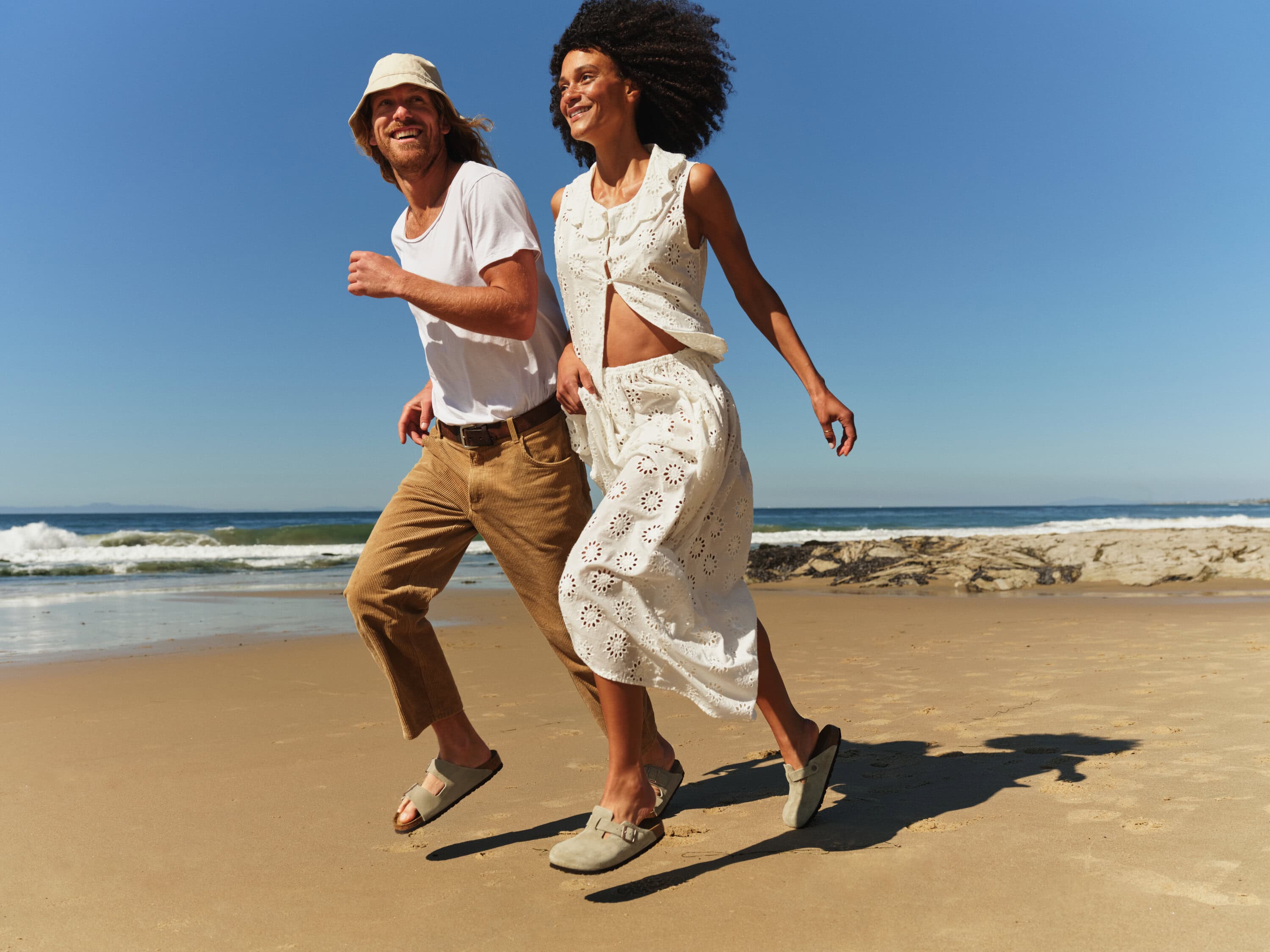 Couple wearing Birkenstock sandals and clogs on Bondi Beach Sydney