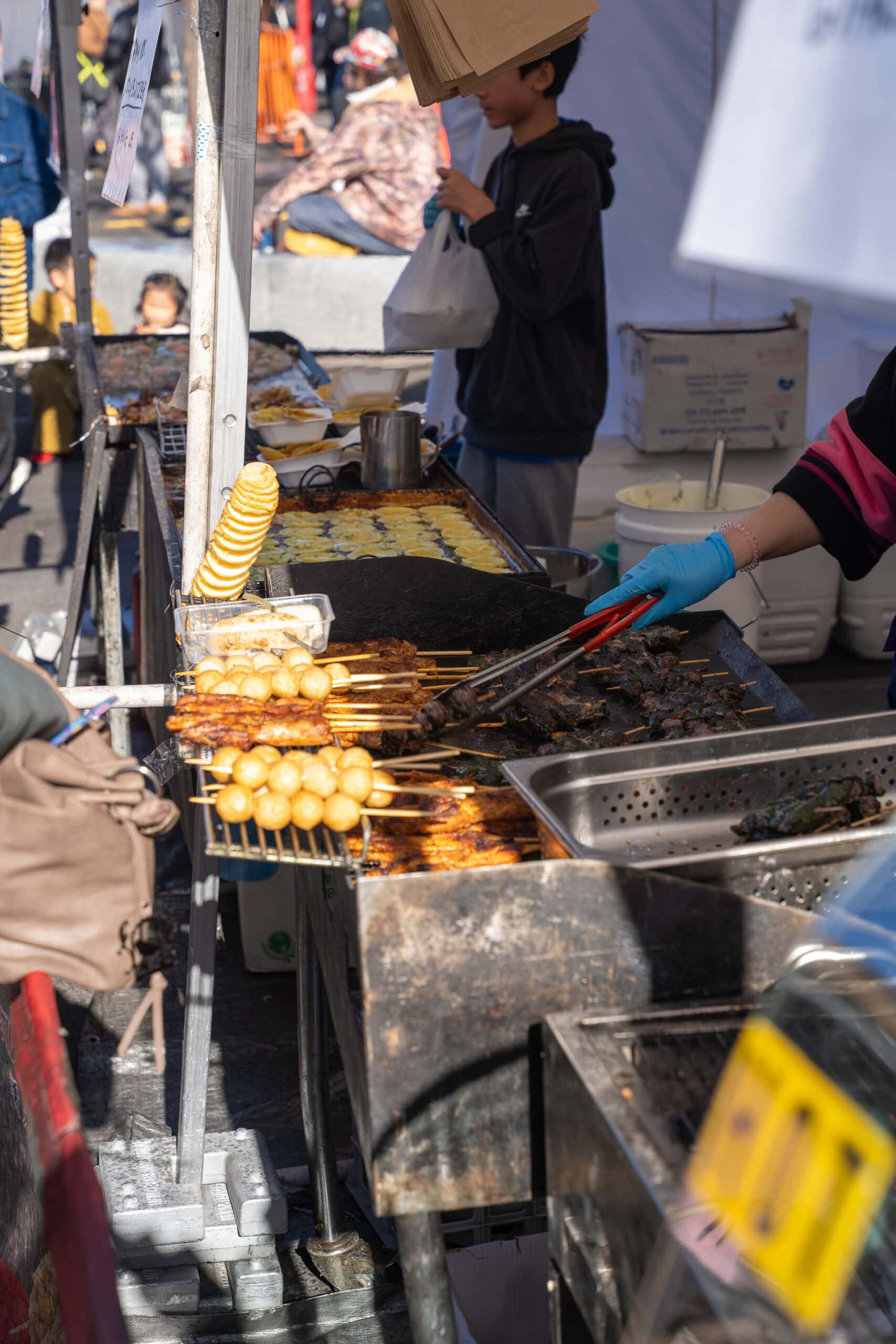 Street food stall grilling skewers, fish balls and other snacks during Springvale Winter Fest.