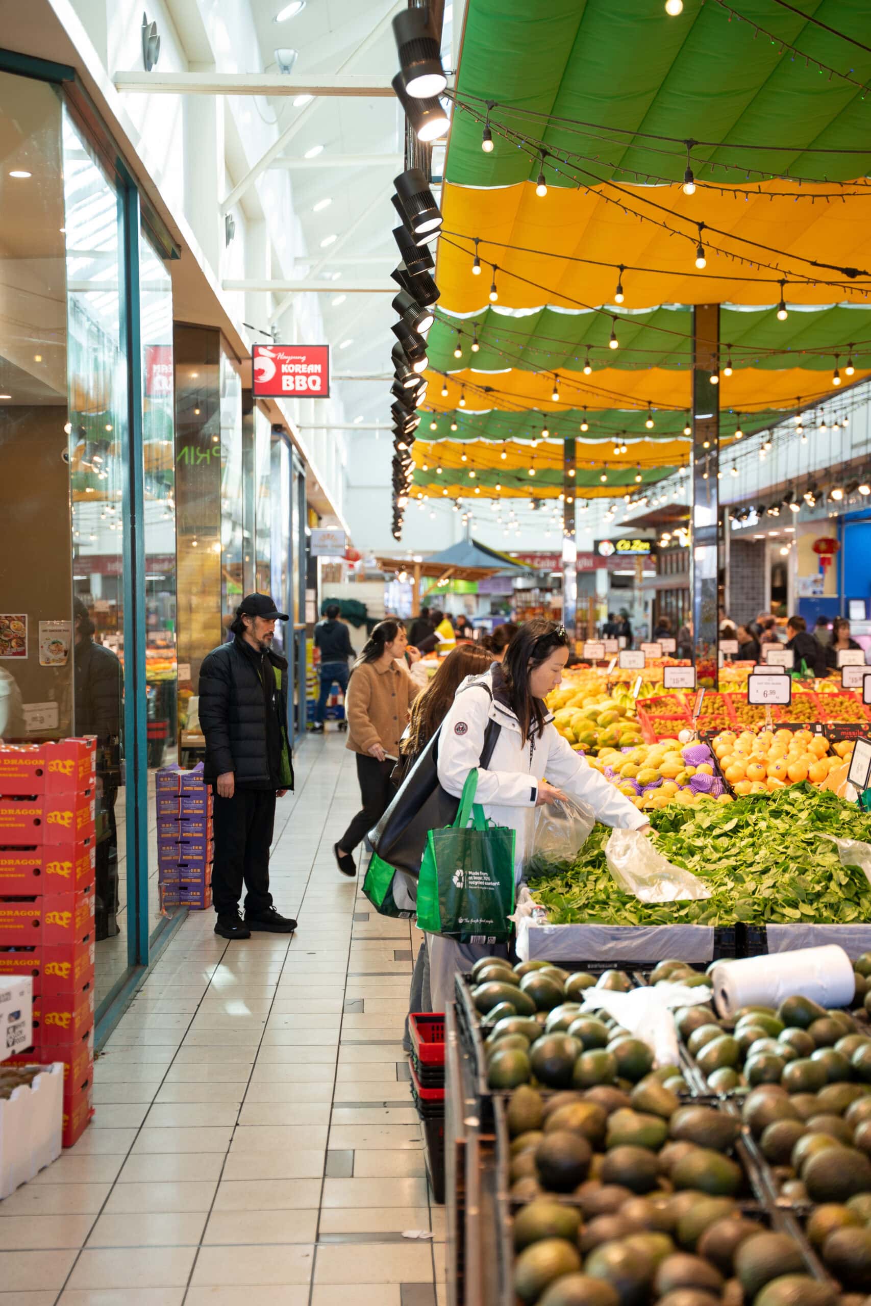 Customer selecting leafy greens inside Thanh Thien Springvale Fresh Market.