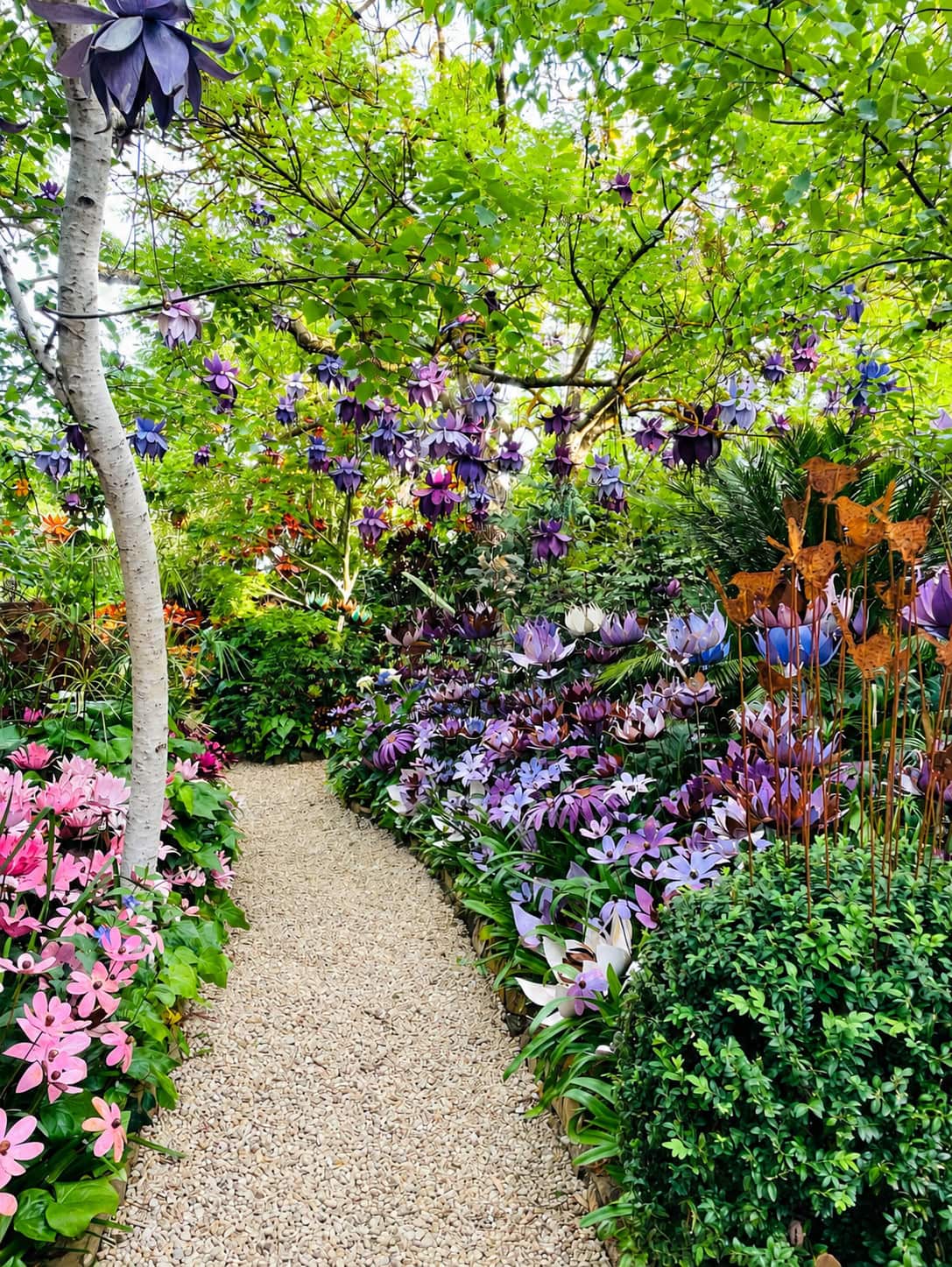 Shades of Gray Castlemaine, a garden path with metal flowers in vibrant colours.