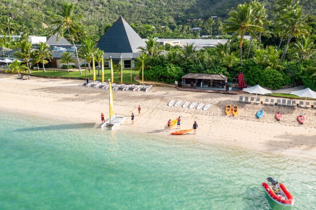 Guests with kayaks and sailboats on the beach at InterContinental Hayman Island