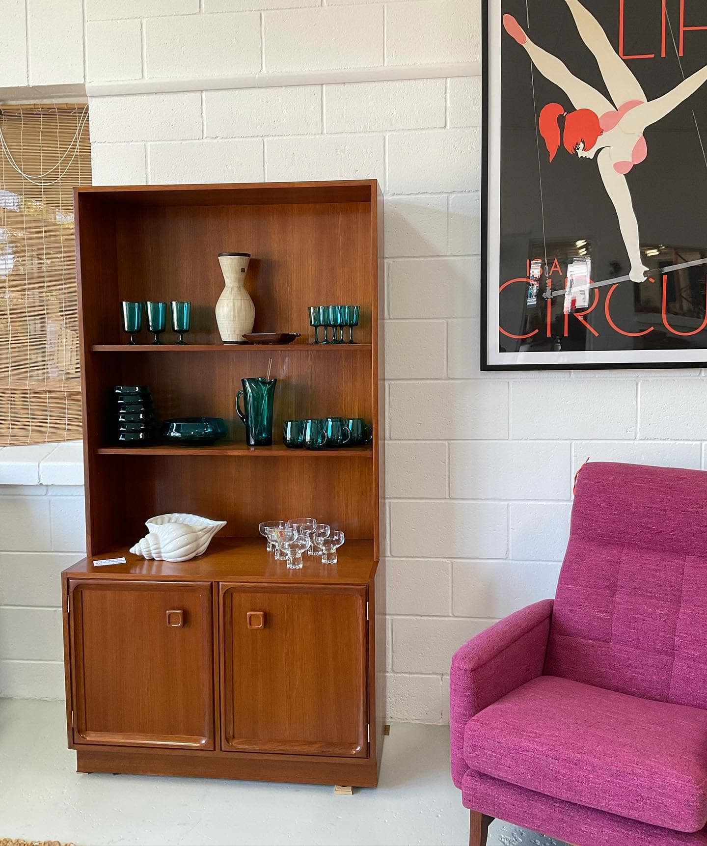 A mid-century bookshelf and purple armchair at Rewind Mid-Century.
