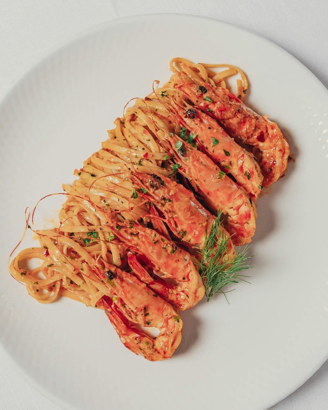 A plate of chilli linguine with six whole prawns at Tillerman Restaurant in Brisbane.