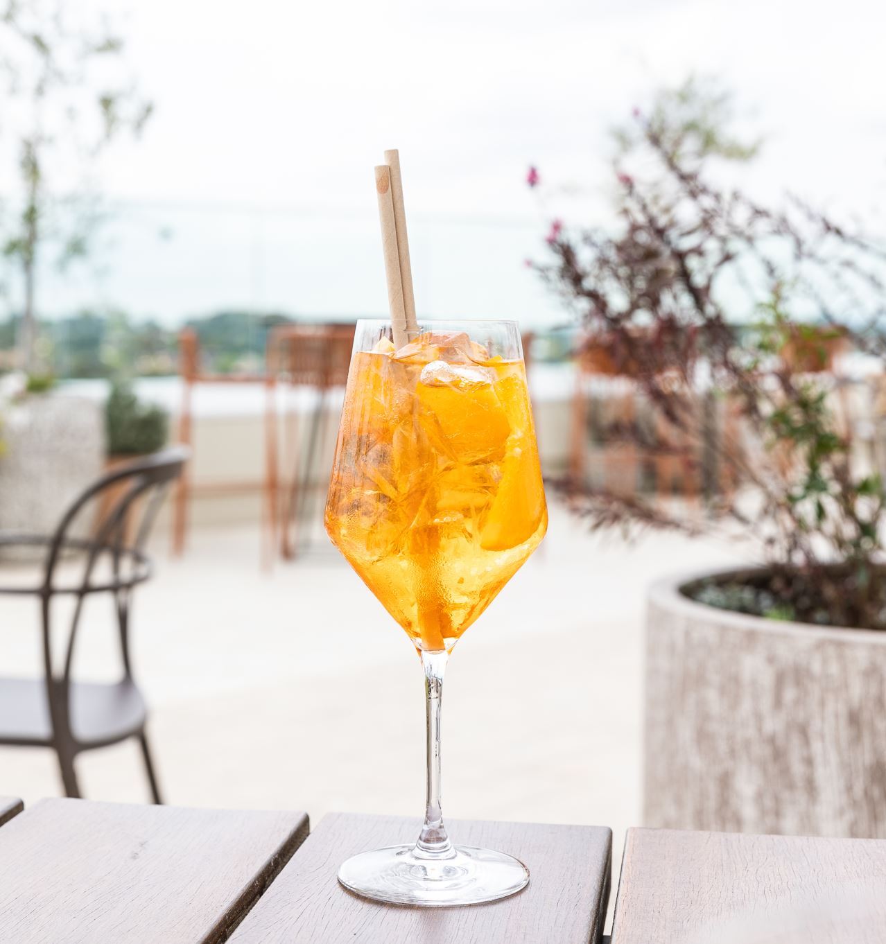 A bright orange cocktail sitting atop a table at Lady Banks Rooftop.