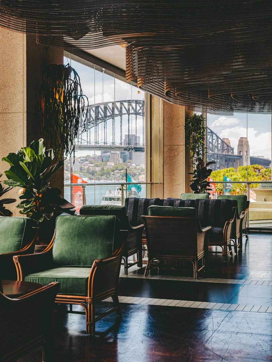 The green velvet seats at Acapulco El Vista, looking directly out onto the Sydney Harbour Bridge.