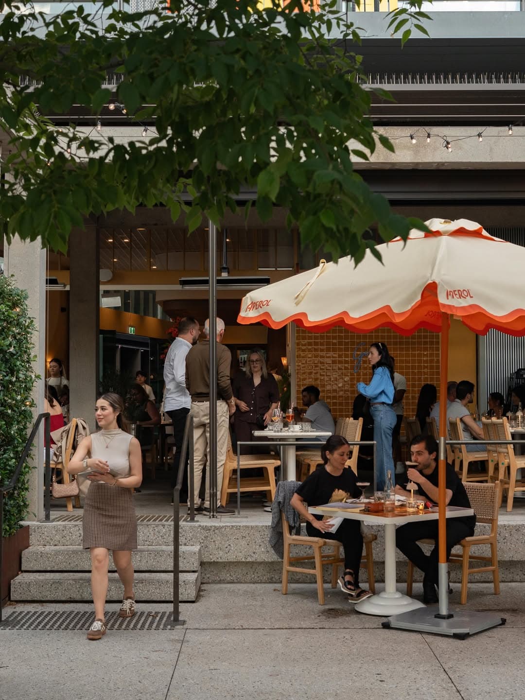 The entrance to Gina Pasta Bar in Barangaroo featuring an orange and cream outdoor umbrella.