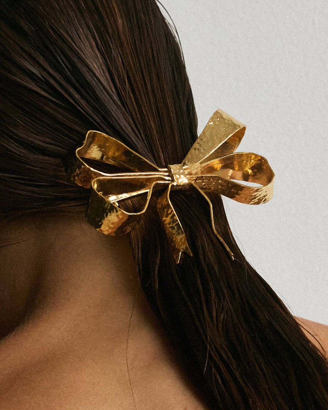 A golden metal hair bow from Christie Nicolaides.
