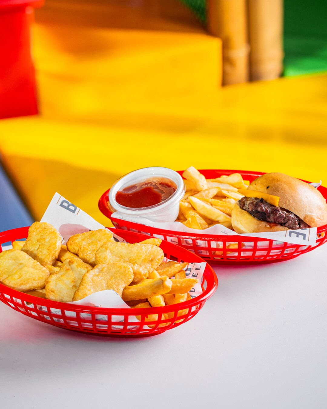 Two kids meals in red plastic baskets at The Belrose Hotel.