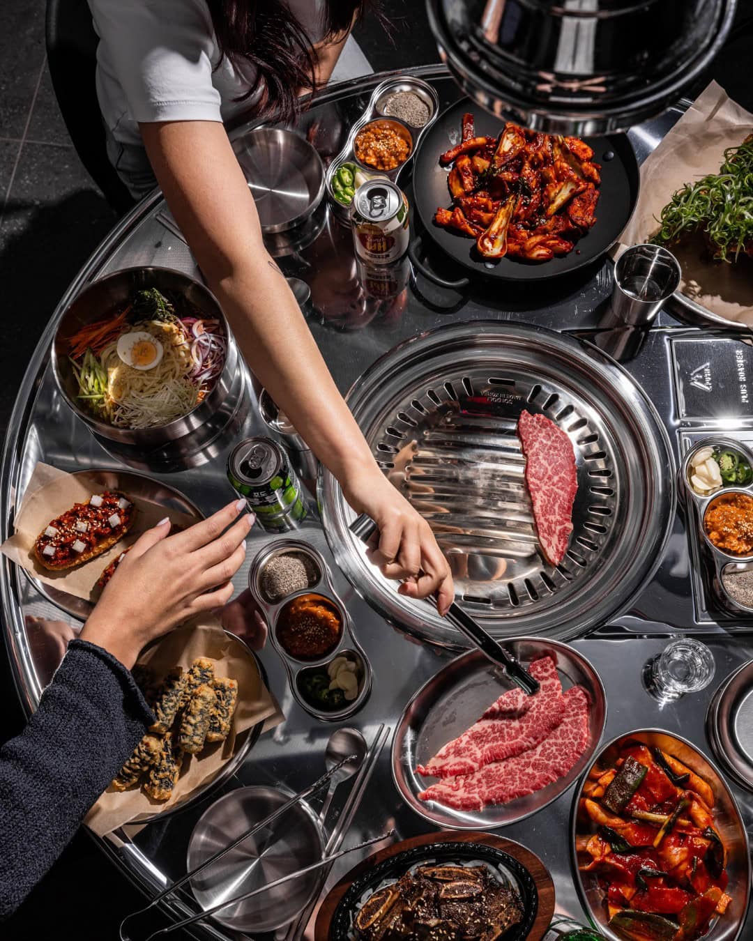 A Korean BBQ table full of raw ingredients ready to grill at Hongdae Pocha in Chippendale.