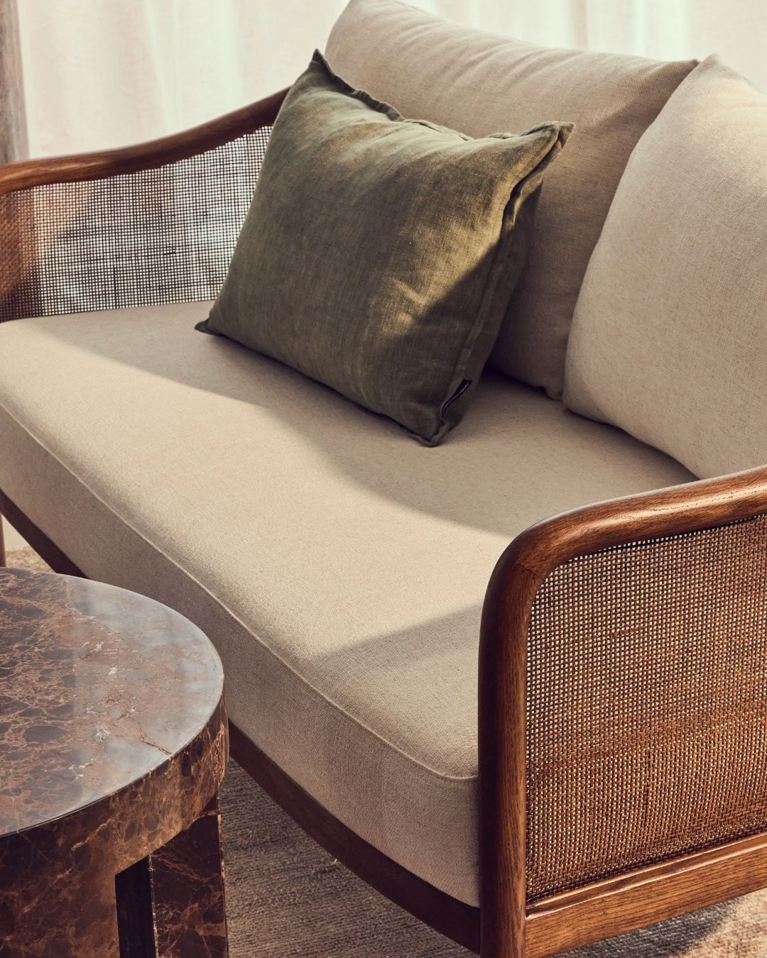 A close up of a rattan-style loveseat from Coco Republic.