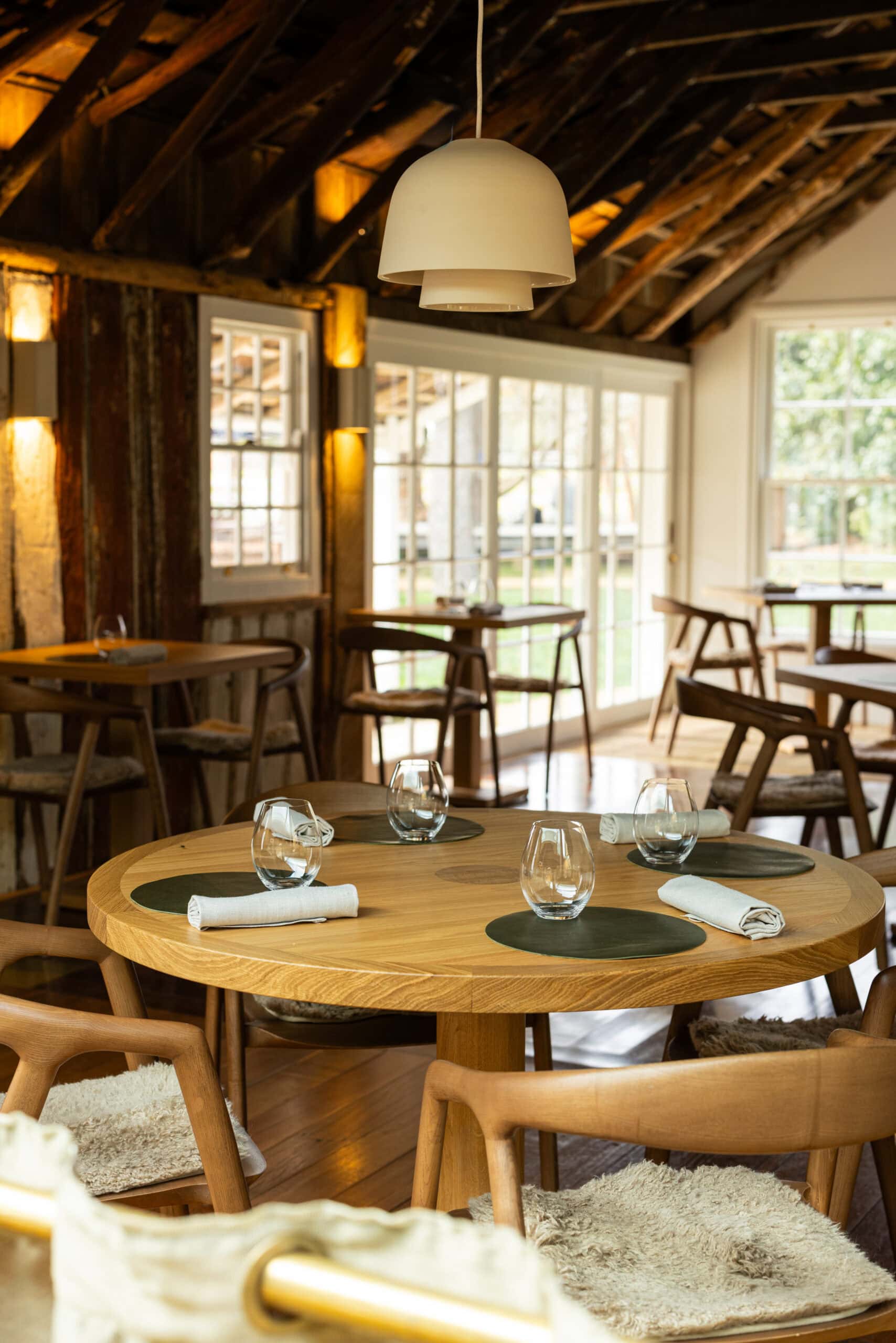Main dining room with round table setting at Three Blue Ducks Burradoo NSW
