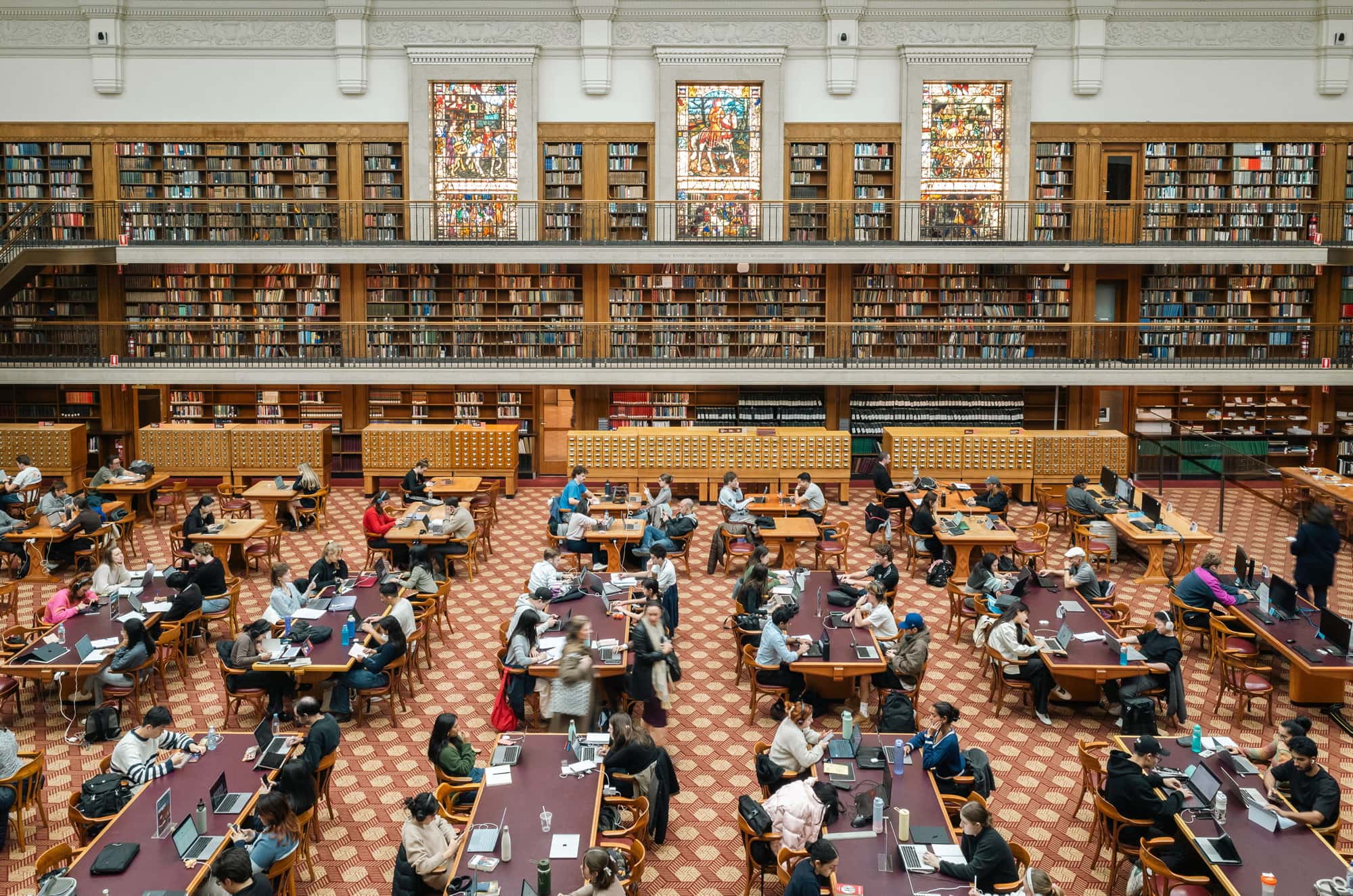 Grand reading room with stained glass windows and bookshelves at State Library of NSW Sydney CBD