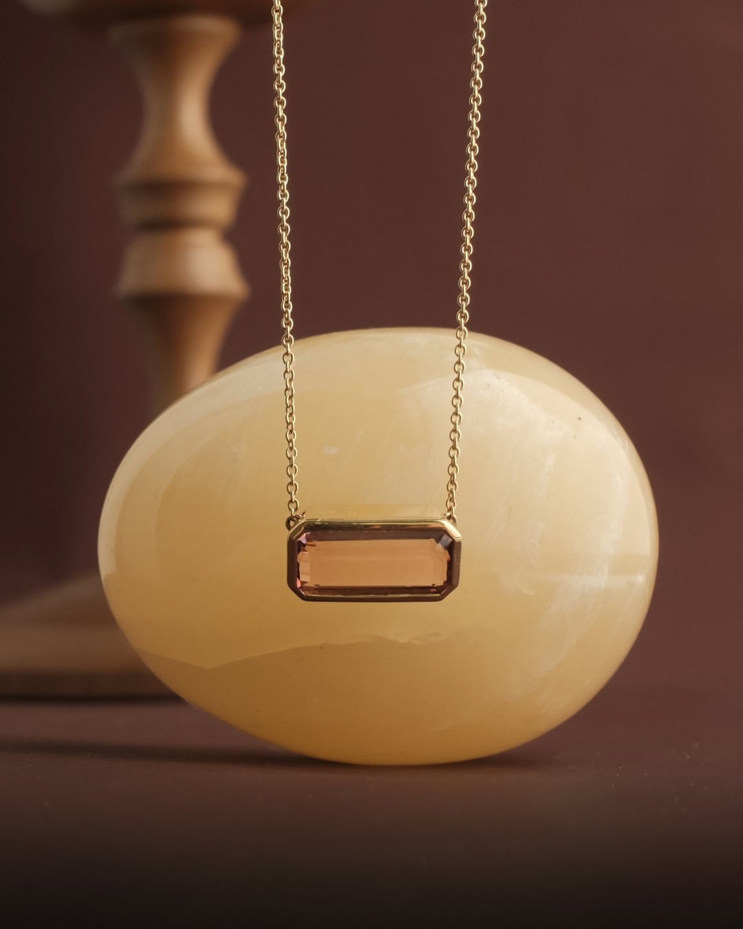 A rectangular diamond necklace against a stone egg from Molten Store in Brisbane.