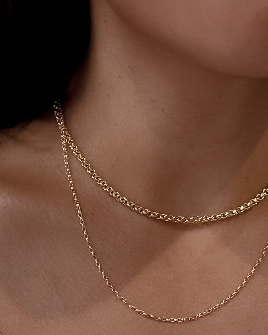 A model's neck with two gold chains around it from Rebellious Grace in Brisbane.