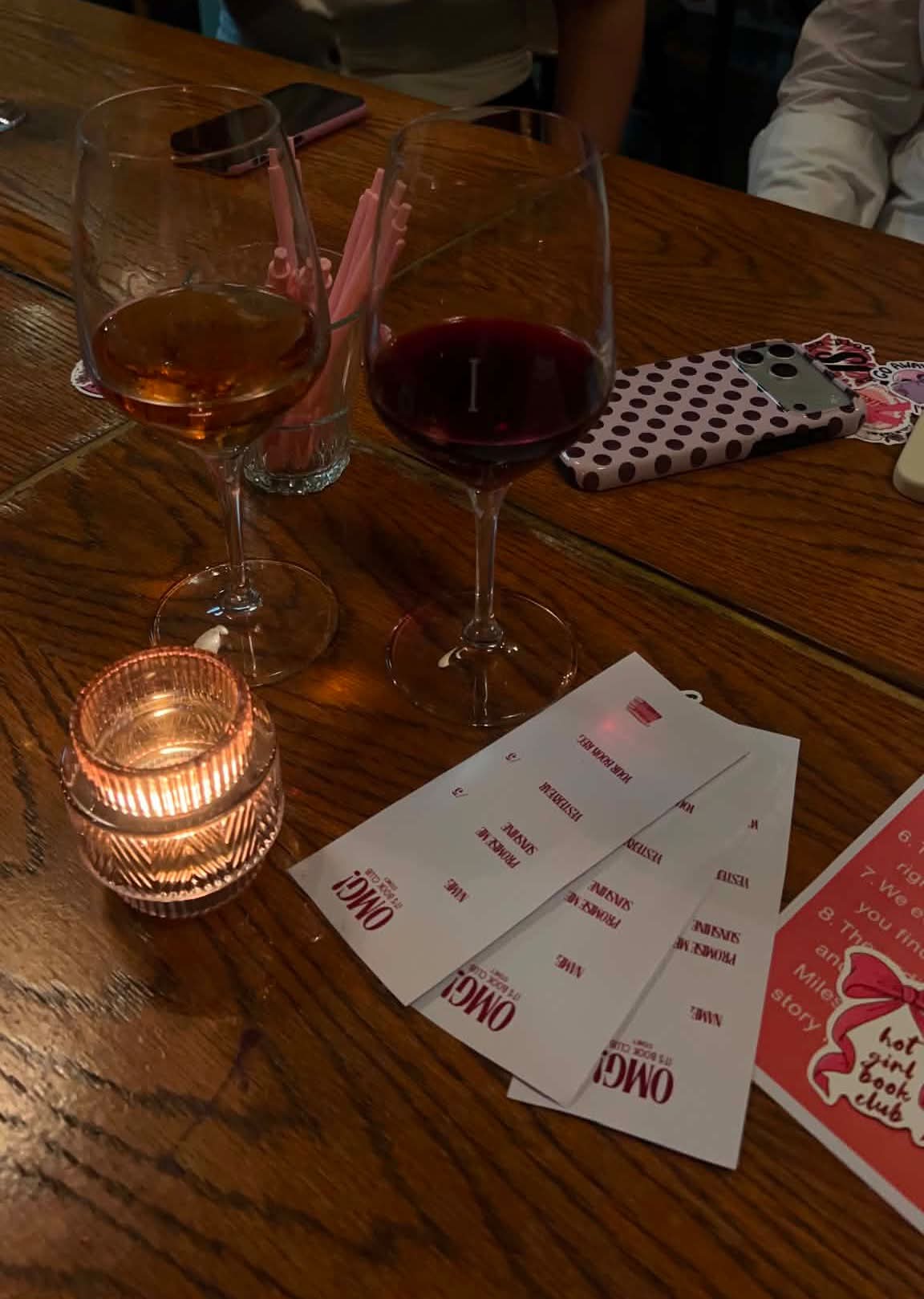 Wine glasses and OMG! It's Book Club discussion cards on wooden table