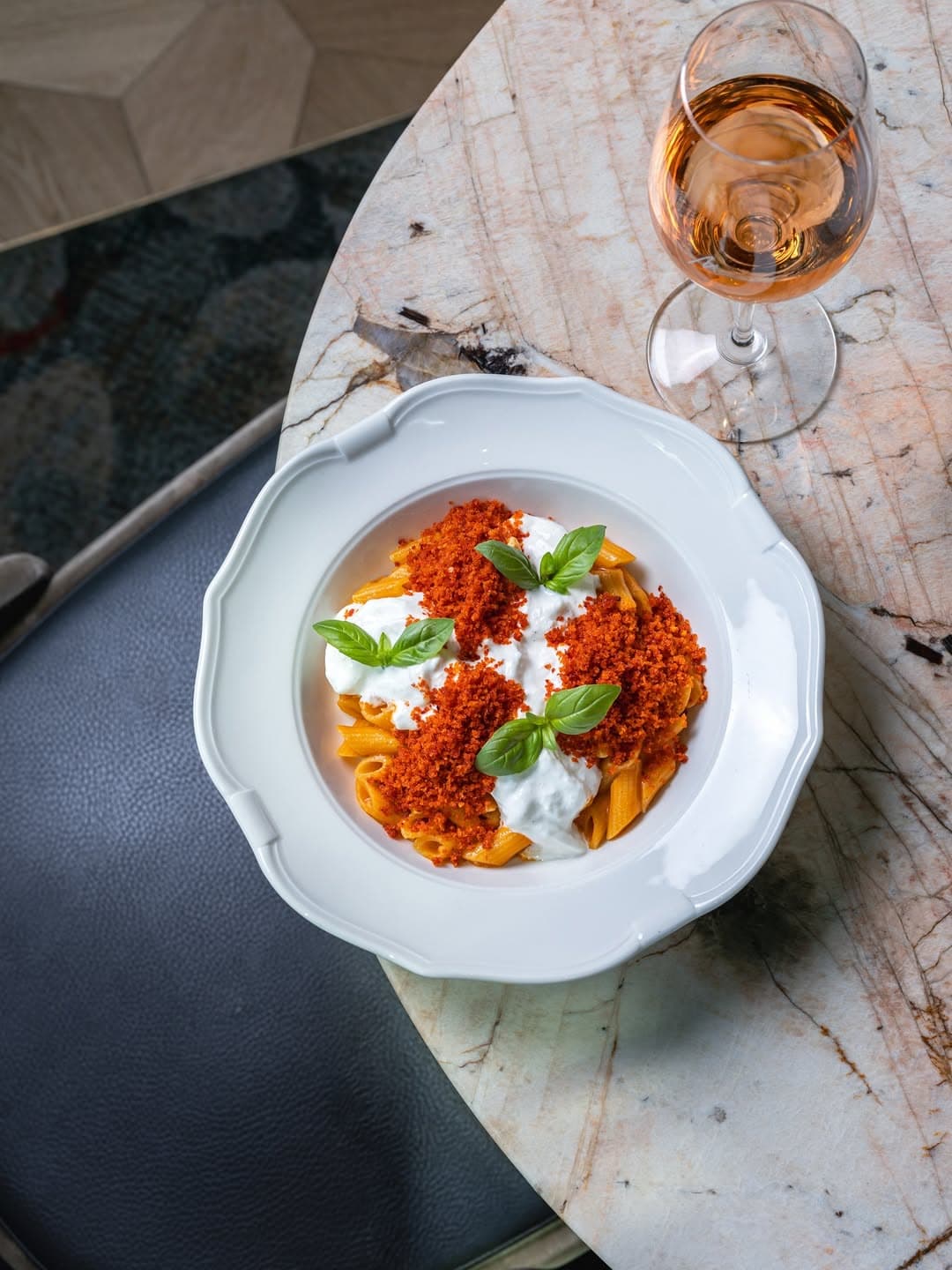 A bowl of pasta and a glass of wine sitting atop a marble table at a'Mare in Barangaroo.