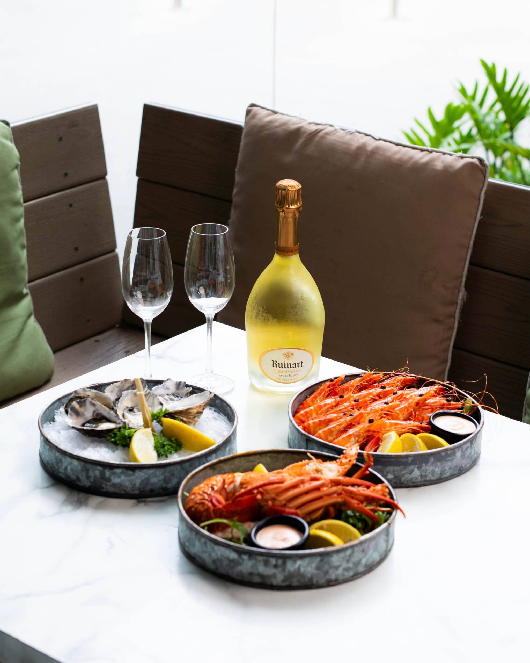 Champagne, lobster and oysters atop a table at Reef in Brisbane.