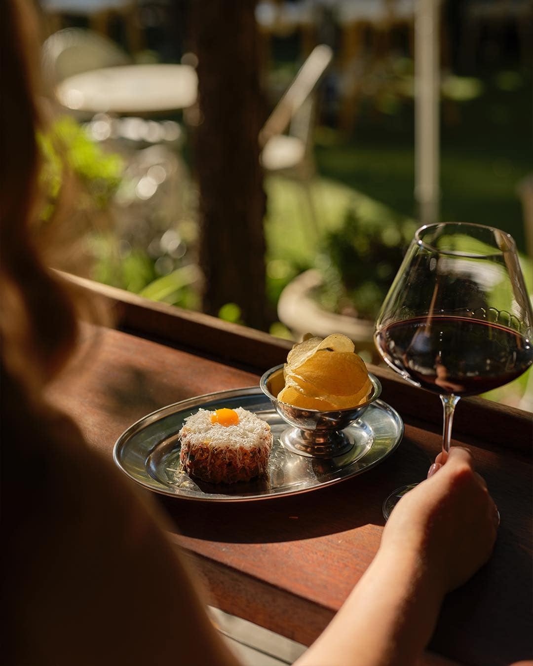 A lady enjoying a glass of wine and steak tartare at The Winery in Surry Hills.