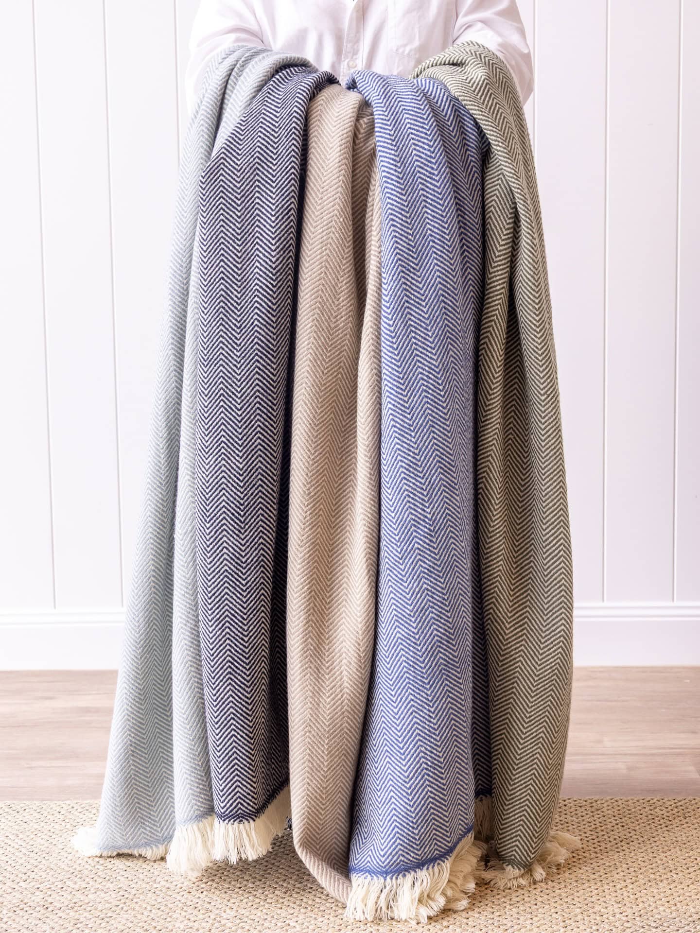 Someone holding three neutral throws from Highgate House in Albion.