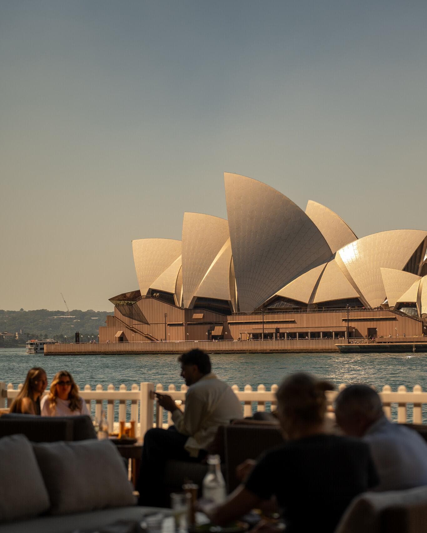 Silhouettes of people at Cruise Bar with the Opera House in the background.