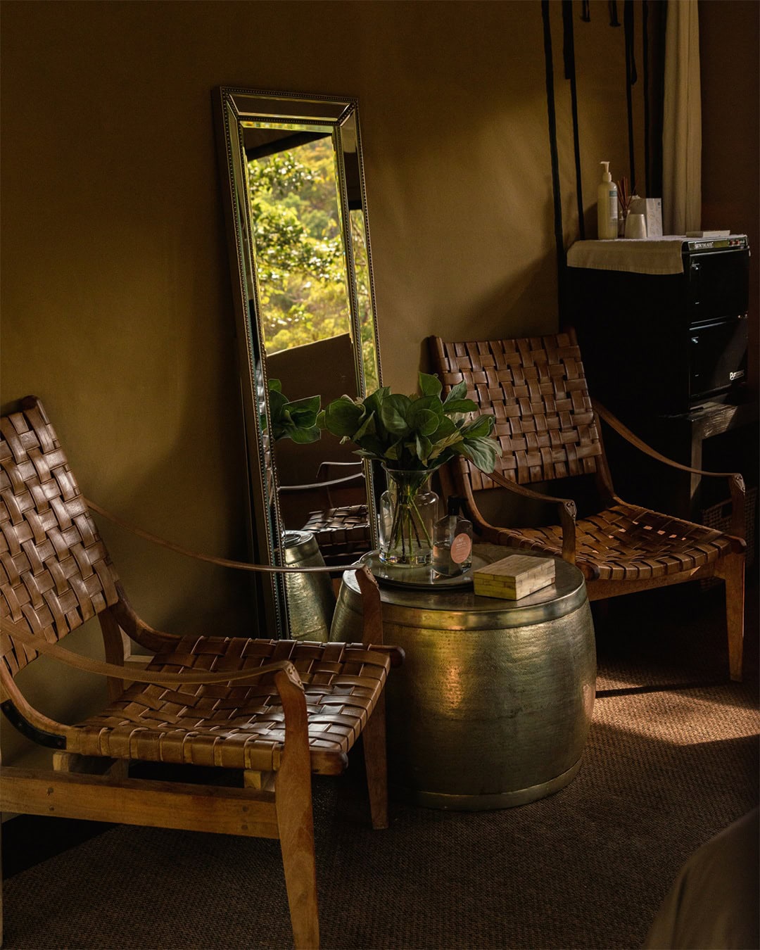 Woven leather chairs and a mirror in the waiting area of Spicers Sangoma Retreat.
