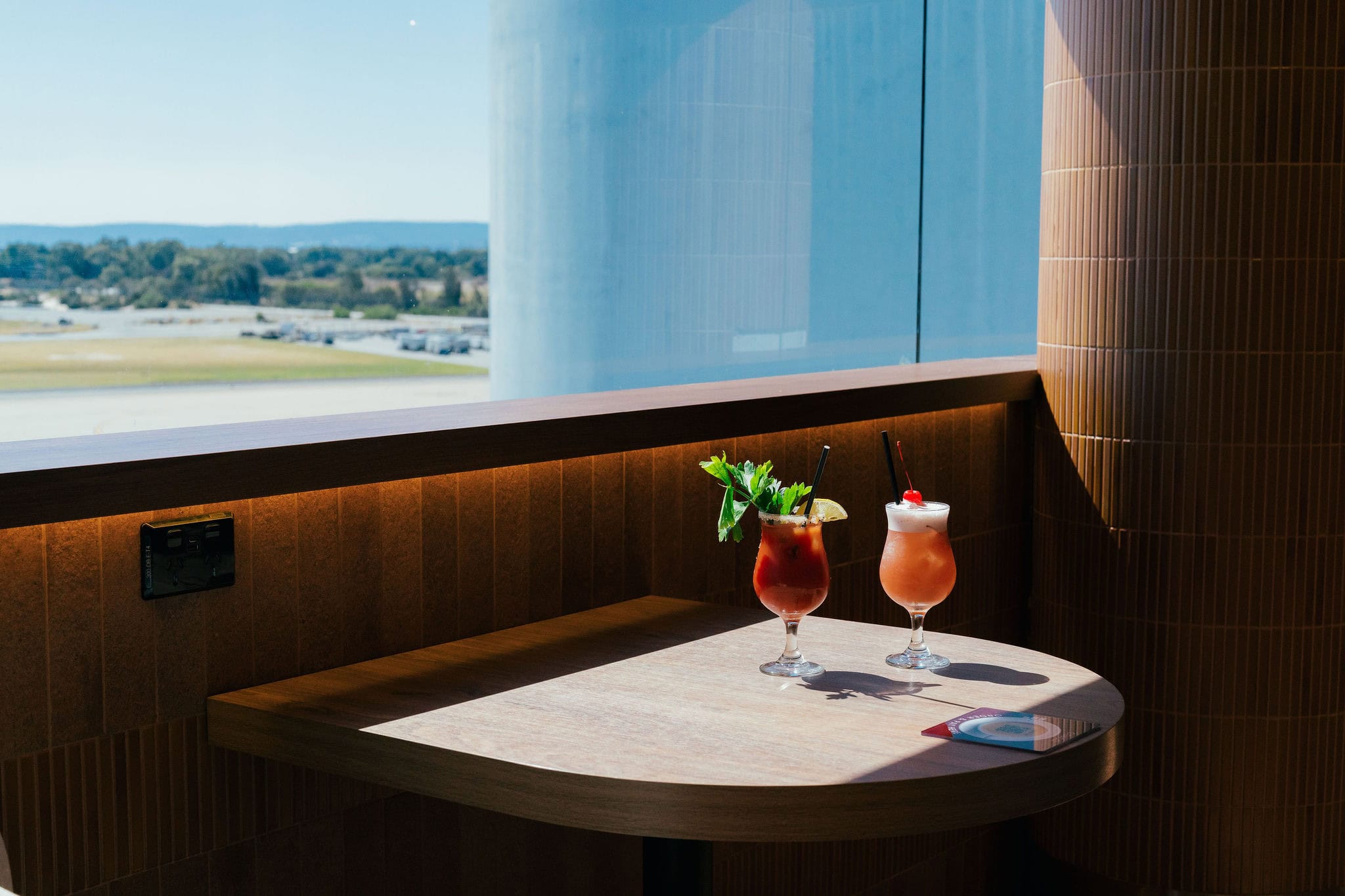 Co & Co bar with spritz cocktails at a table by a window looking out to the airport Perth Airport International terminal