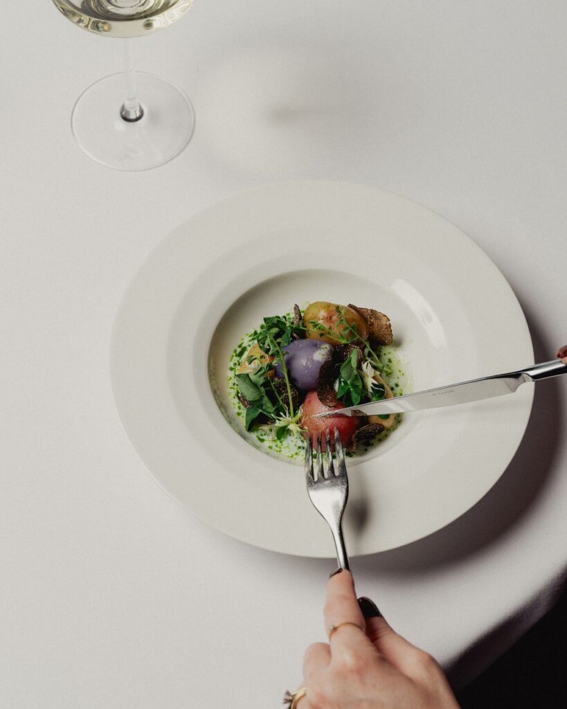 someone tucking into a plate of baby potatoes at Aria in Circular Quay.