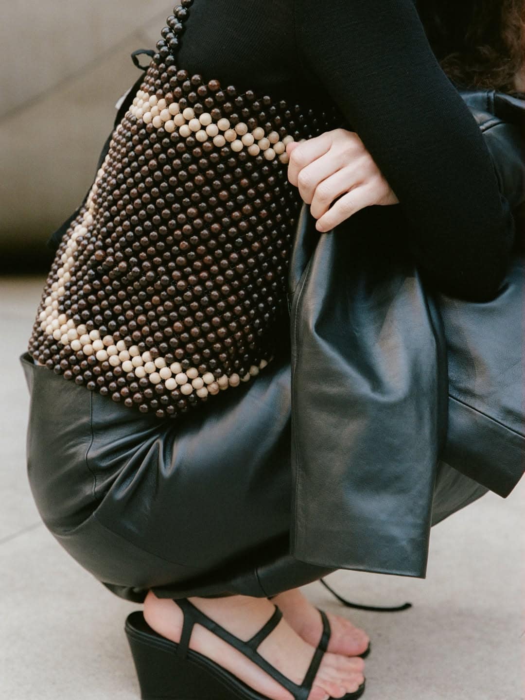 A woman crouching down wearing a beaded top from St Agni.
