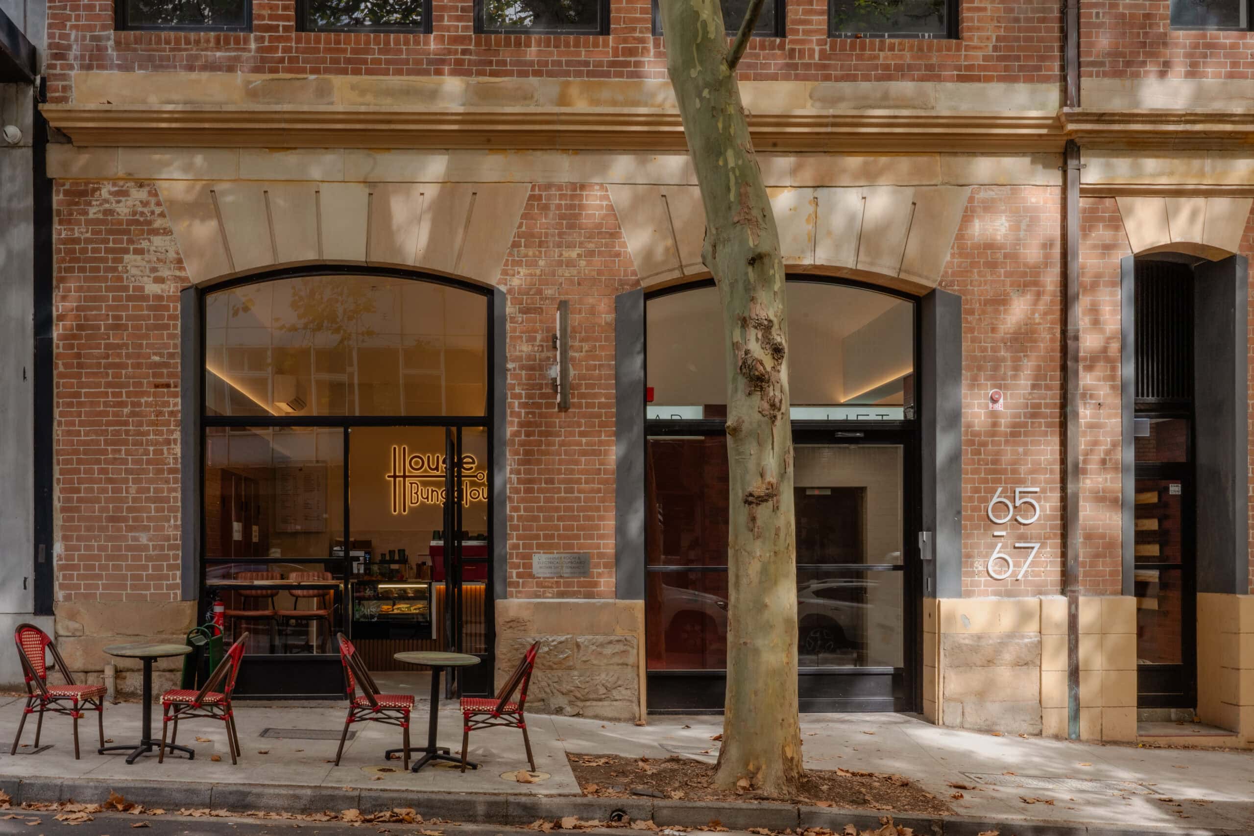 Cafe shopfront with neon sign and outdoor seating House of Bungalow Surry Hills Sydney