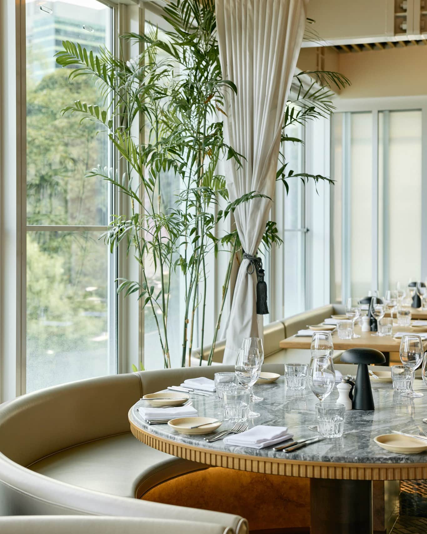 The elegant dining room and curved banquette seating at Stilts restaurant in Brisbane.