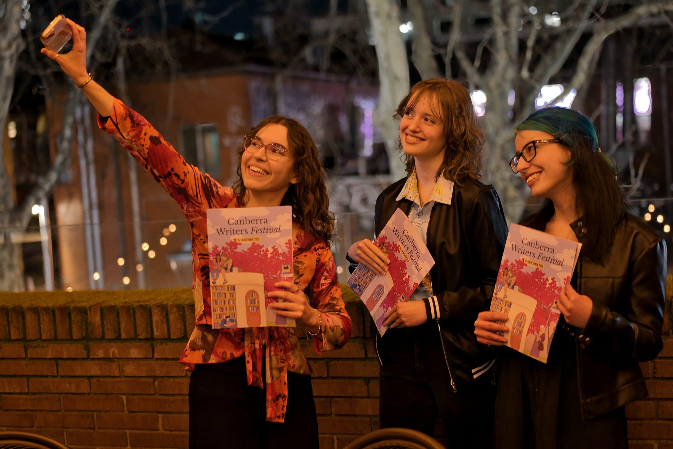 Festival attendees taking a selfie with programs at the Canberra Writers Festival