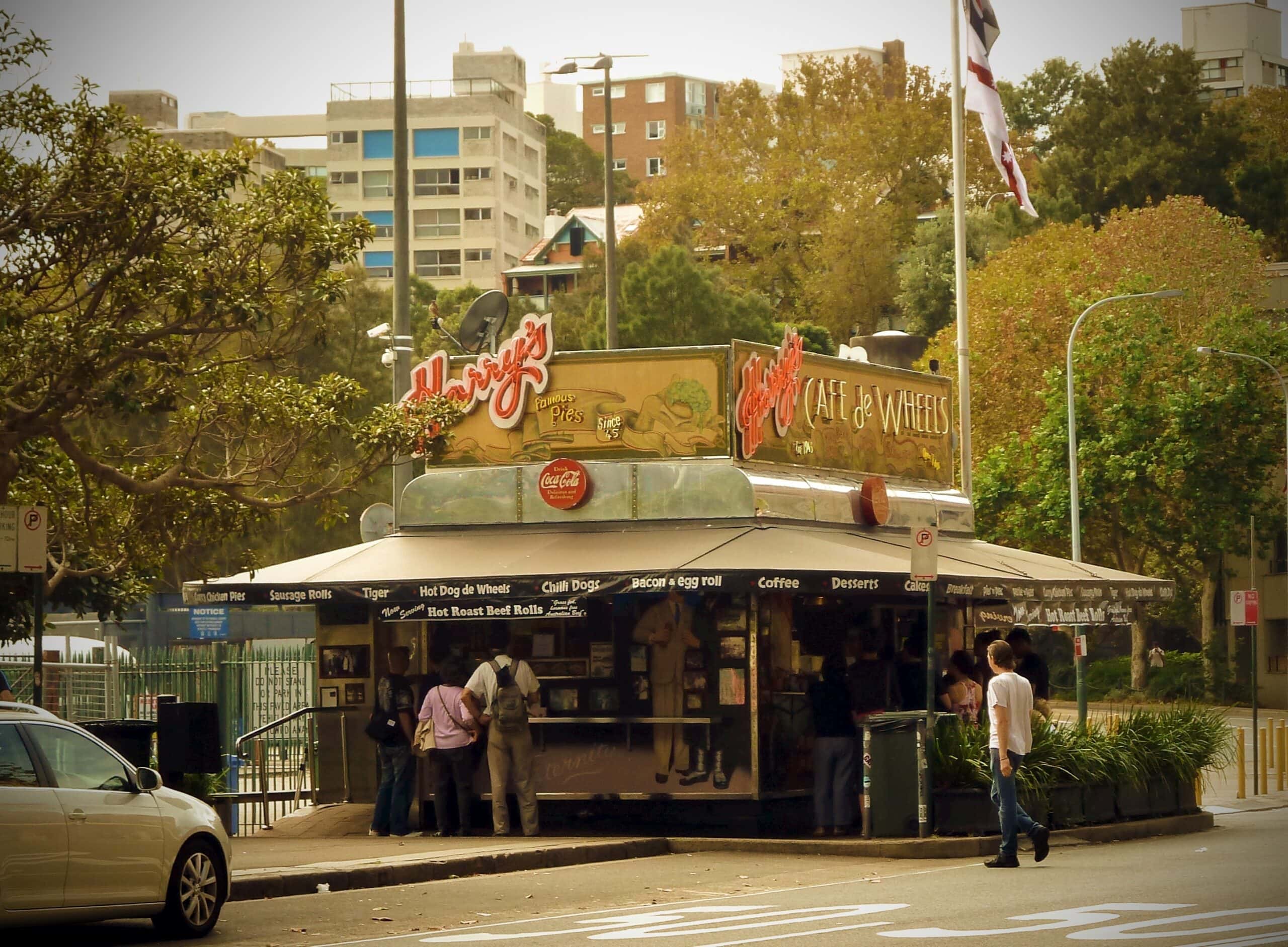 Exterior of Harry's Cafe de Wheels food kiosk with customers queuing, Woolloomooloo, Sydney