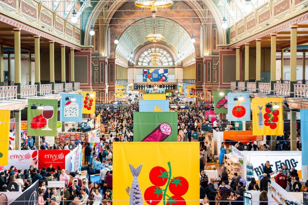 Colourful food banners hanging above market stalls at Royal Exhibition Building Carlton Melbourne