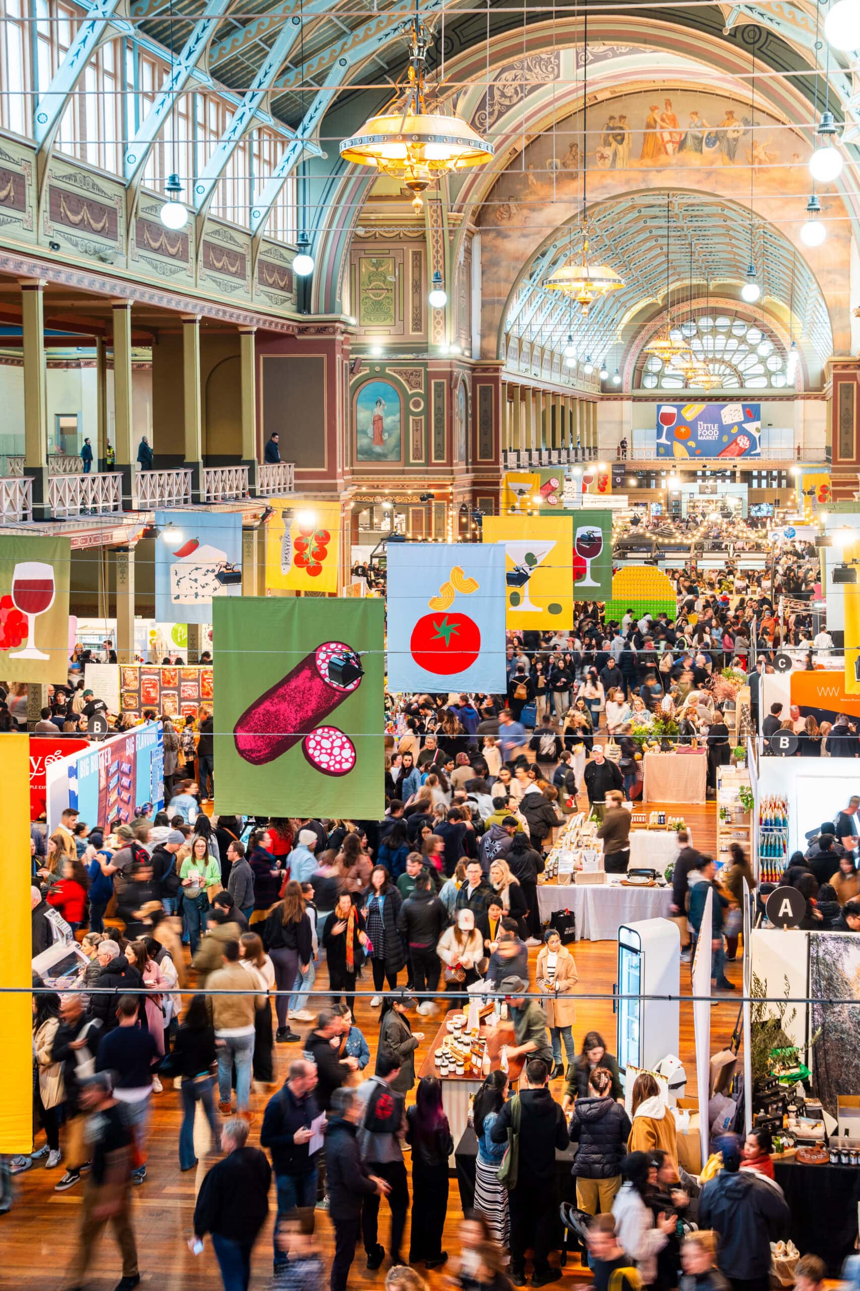 Colourful food banners hanging above market stalls at Royal Exhibition Building Carlton Melbourne