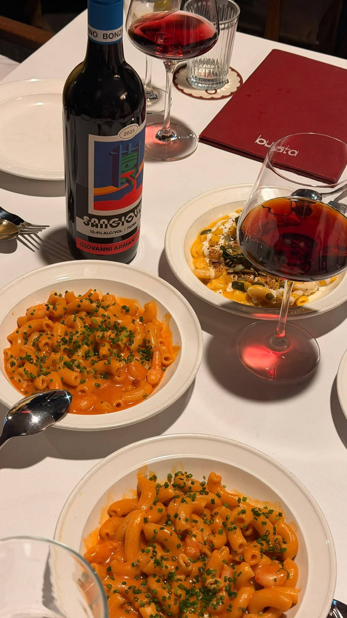 Rigatoni pasta dishes and red wine on table at Busta Manly Sydney