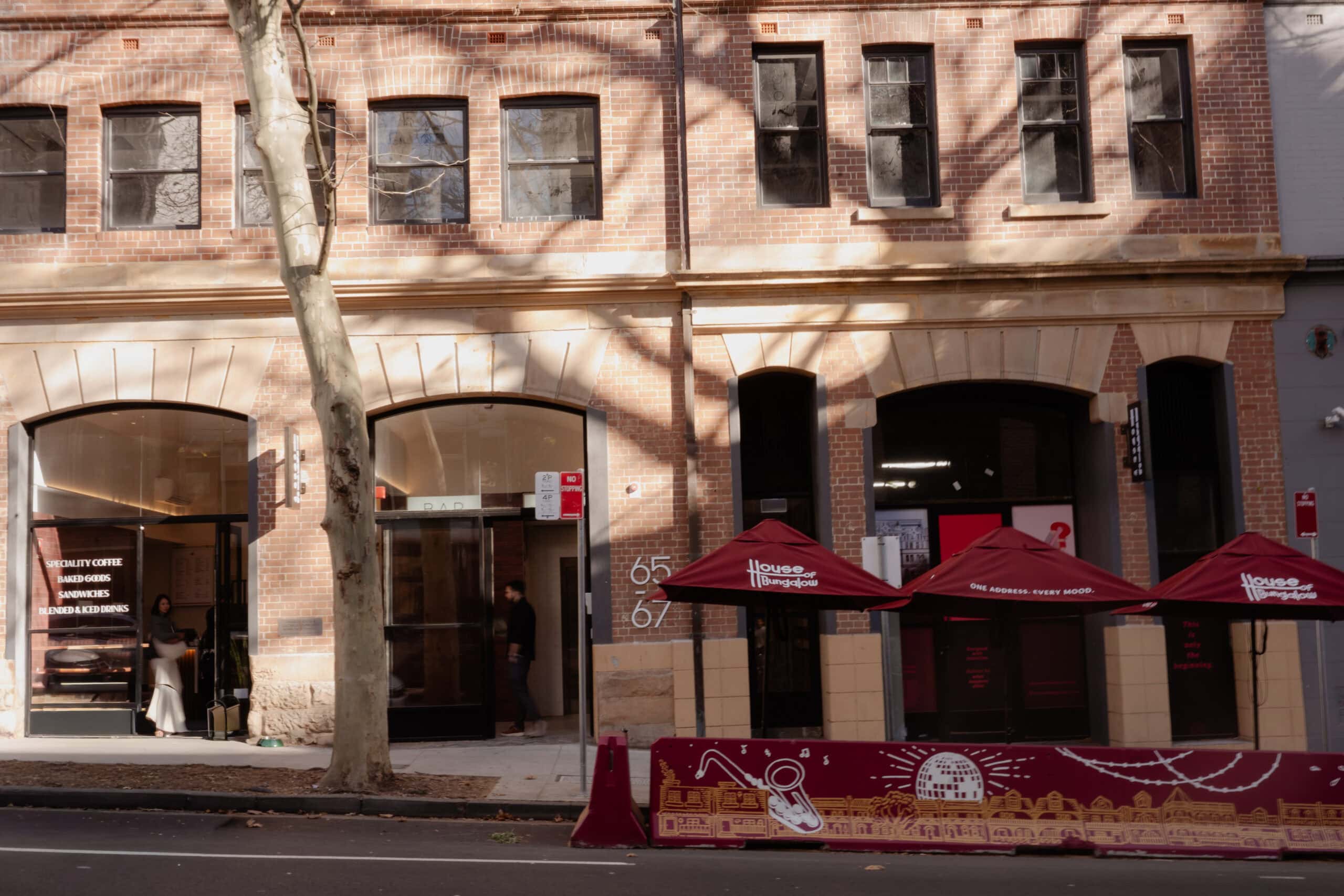 Street exterior with red umbrellas and signage House of Bungalow Surry Hills Sydney