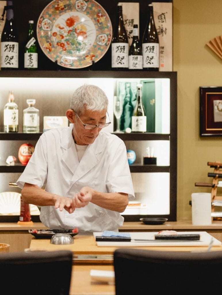 A chef preparing sushi at Gold Class Daruma in Sydney.