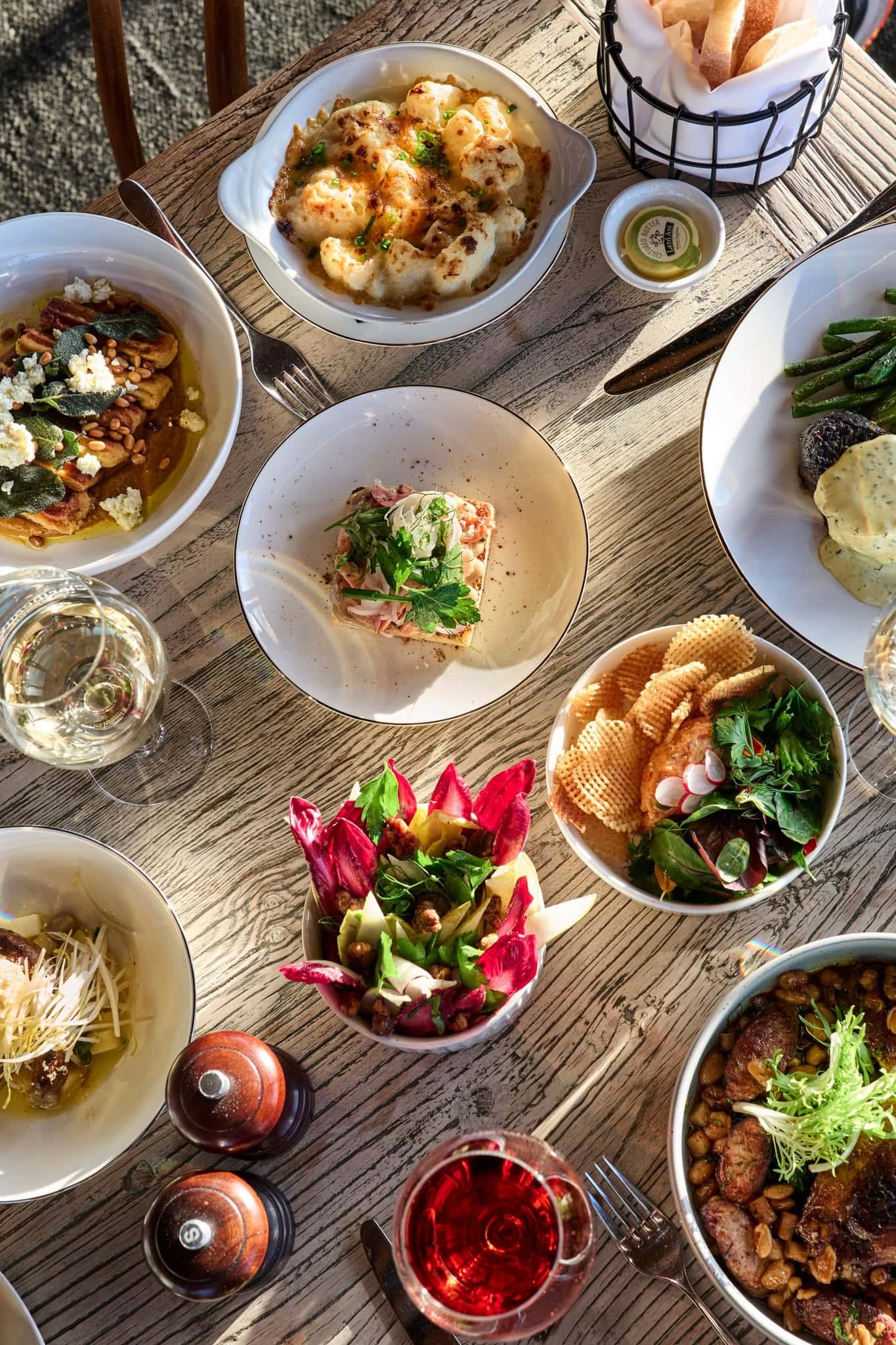 Shared lunch spread with seasonal dishes and wine at Claribeaux restaurant in Torquay, on Victoria’s Surf Coast.