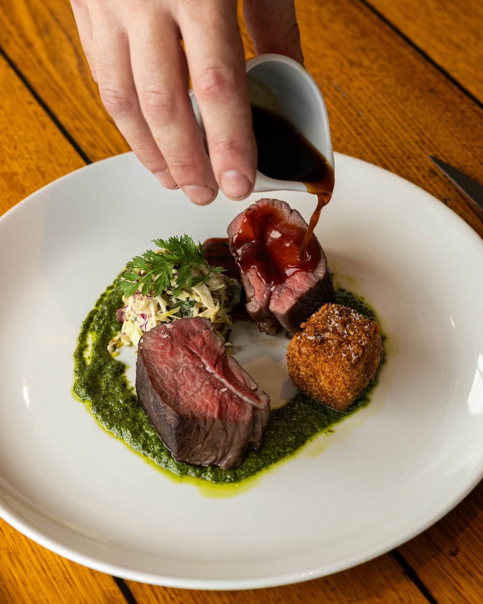 Beef main course with green sauce, slaw and crisp croquette served at Donovans restaurant in St Kilda, Melbourne.
