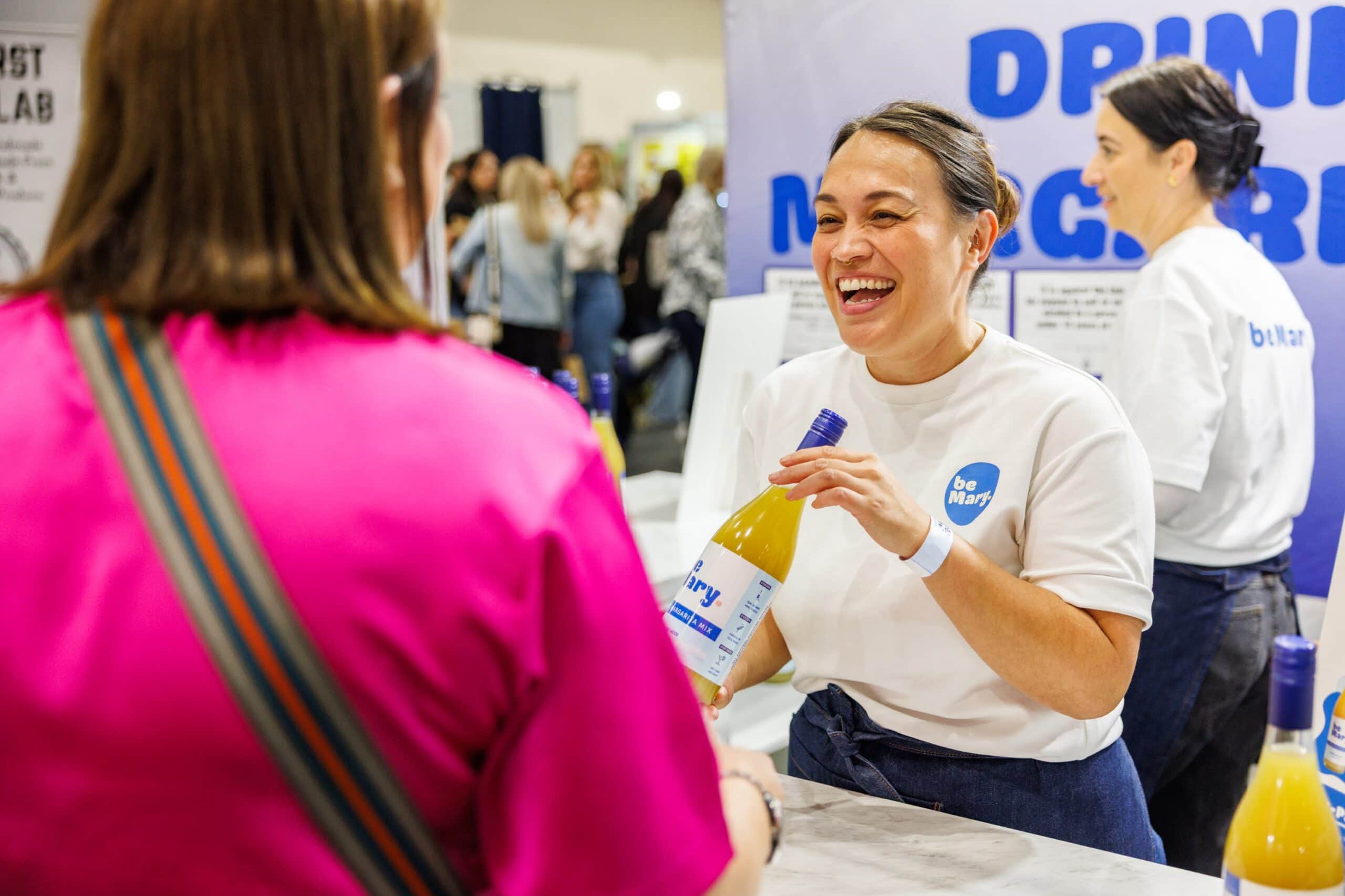 A woman receiving a drink sample at the good food and wine show