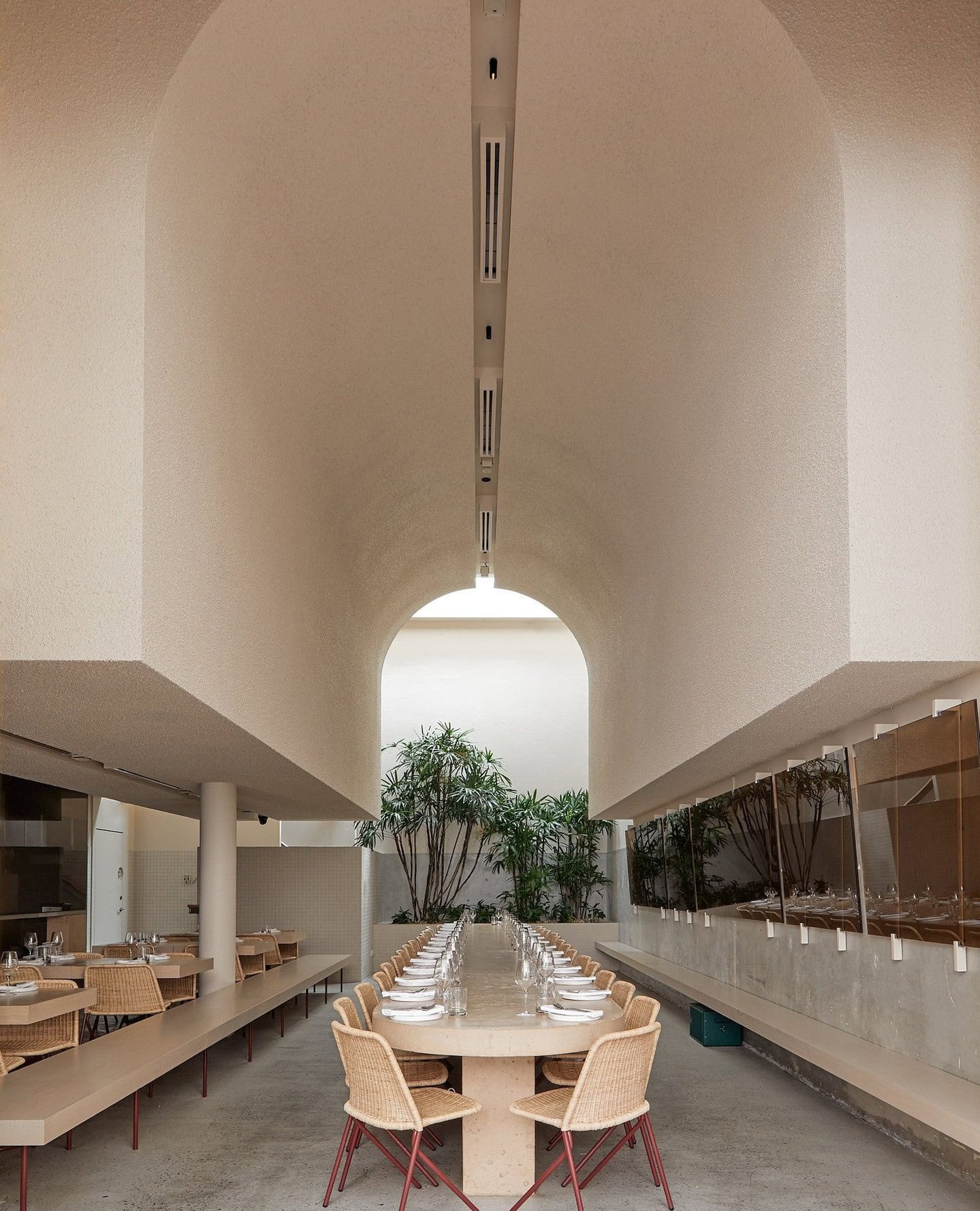 An expansive restaurant with high, arched ceilings and light-coloured furniture.