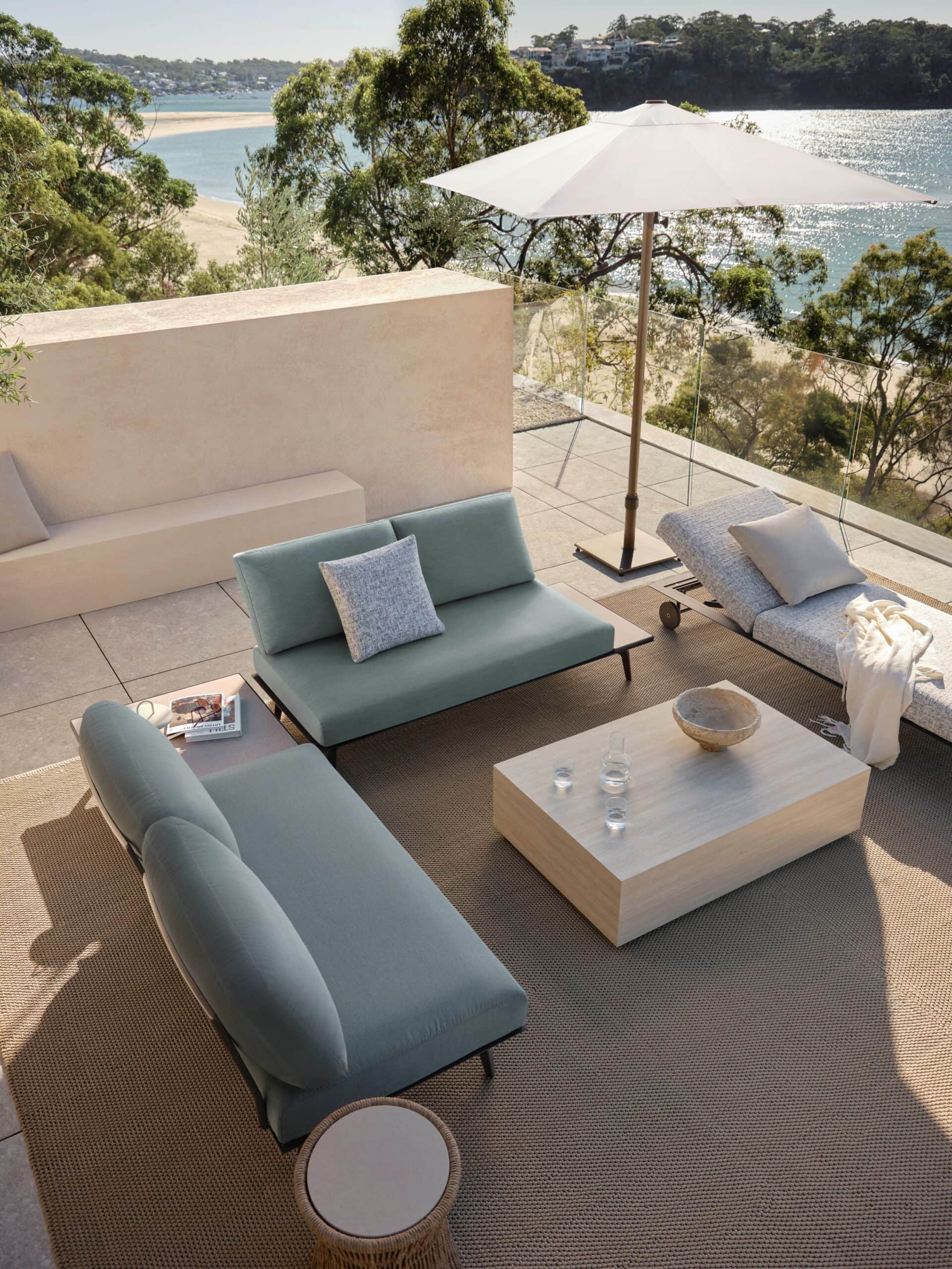 King Cove outdoor lounge package by King Living styled on a terrace overlooking the beach