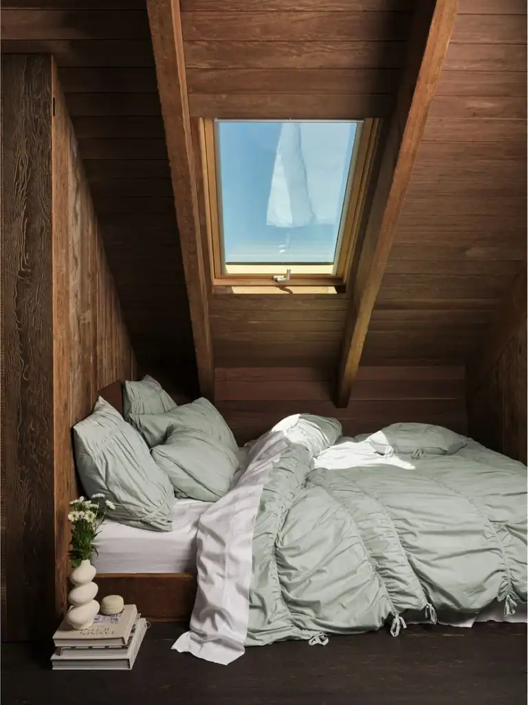 Sage green bedding from Linen House's Suite Escape collection styled in a timber cabin attic