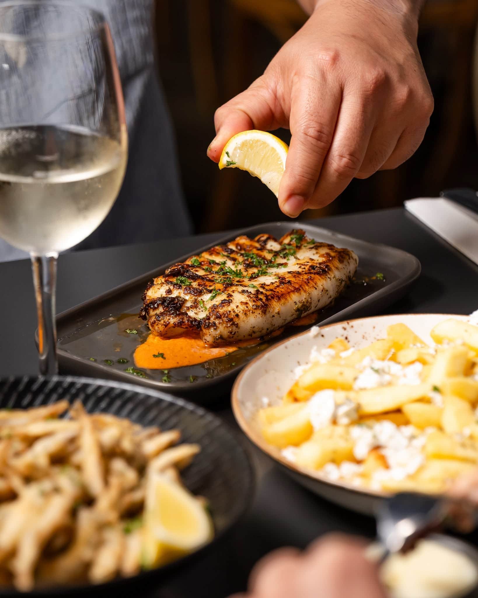 Grilled seafood finished with fresh lemon at Mavs Greek Restaurant in Geelong, served with Greek-style sides.