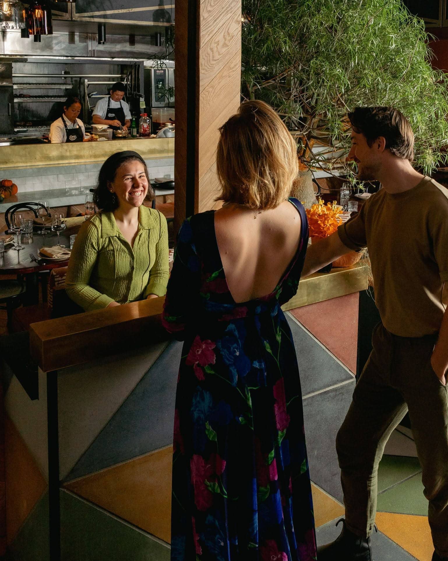 Diners inside Pastuso in Melbourne CBD, with the open kitchen and contemporary Peruvian restaurant interior in view.